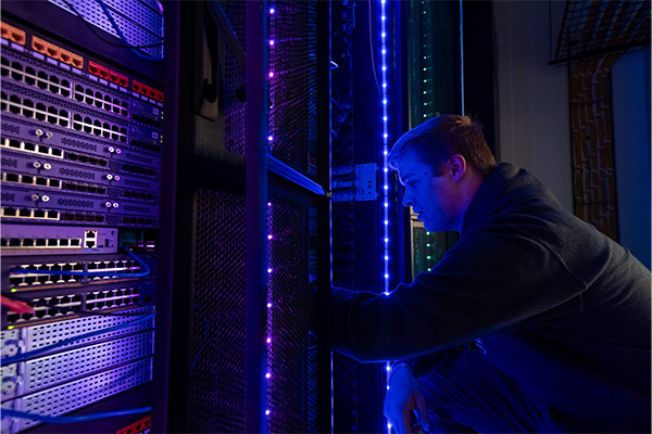 A student working in the server room at Dakota State University.