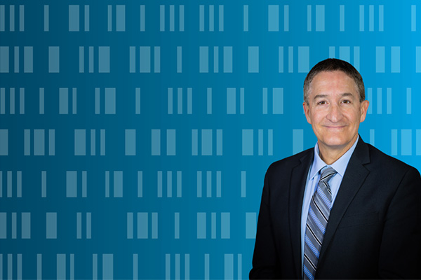 Director of Municipal Cybersecurity Grant Program Mike Waldner pictured in front of a blue gradient background with coding overlayed over it.