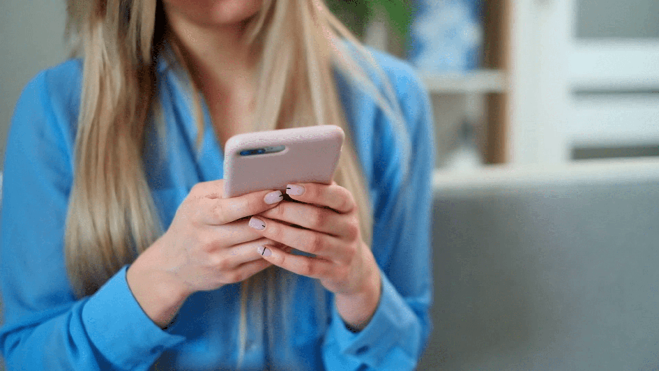 Woman in blue DSU shirt texting on smart phone